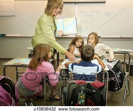 Teacher instructing in a classroom View Large Photo Image Stock Image - Teacher instructing in a classroom. Fotosearch