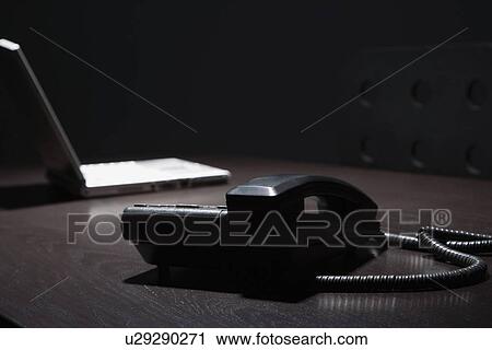 Telephone and laptop on a table View Large Photo Image Stock Image - Telephone and laptop on a table. Fotosearch