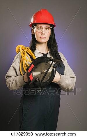 Tradeswoman holding an extension cord and a power saw View Large Photo Image Stock Image - Tradeswoman holding an extension cord and a power saw. Fotosearch