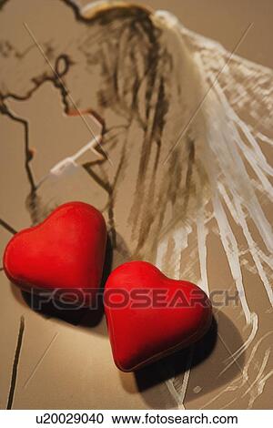 Stock Image - Two red hearts on sketch of wedding couple. Fotosearch