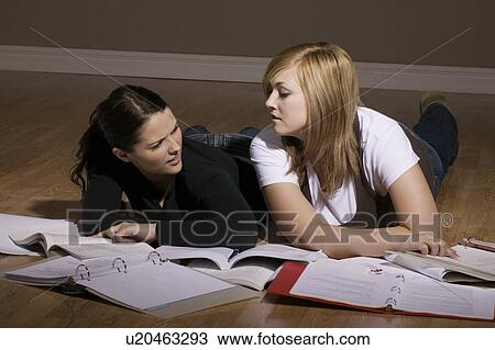 Two women studying on the floor View Large Photo Image Stock Image - Two women studying on the floor. Fotosearch