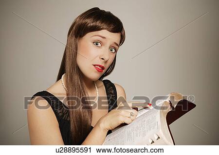 Stock Image - Woman confused while reading. Fotosearch