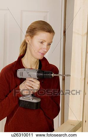 Stock Image - Woman drilling. Fotosearch