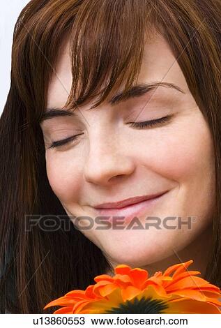 Woman enjoying smell of flower View Large Photo Image Stock Image - Woman enjoying smell of flower. Fotosearch