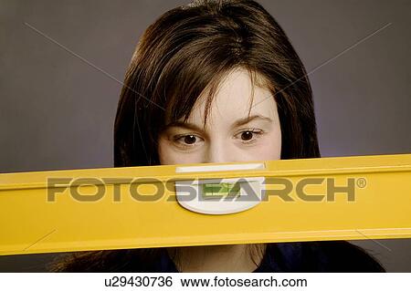 Stock Photograph - Woman holding a spirit level. Fotosearch