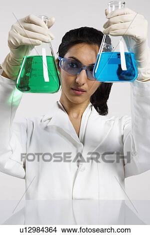 Woman holding two beakers up View Large Photo Image Picture - Woman holding two beakers up. Fotosearch