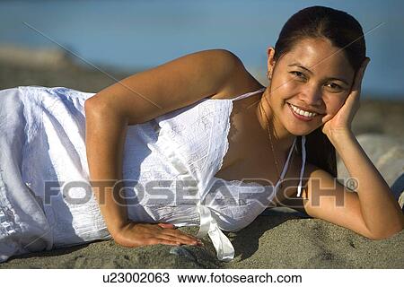 Woman laying on the beach View Large Photo Image Stock Image - Woman laying on the beach. Fotosearch