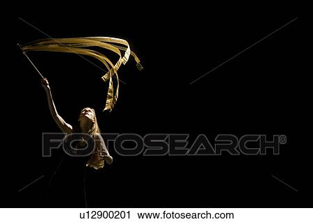 Stock Image - Woman waving flag in black background. Fotosearch