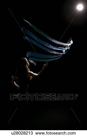 Stock Image - Woman waving flag in spotlight. Fotosearch