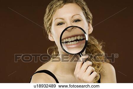 Stock Photo - Woman with magnifying glass over her mouth. Fotosearch