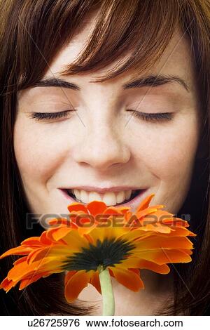 Stock Photograph - Women enjoying smell of flower. Fotosearch