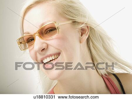 Stock Image - Young Blond woman wearing sunglasses. Fotosearch