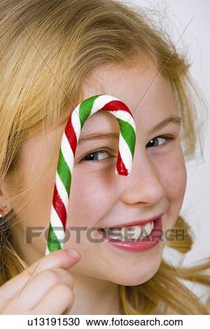 Young girl holding a candy cane View Large Photo Image Stock Image - Young girl holding a candy cane. Fotosearch