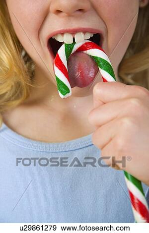 Young girl licking candy cane View Large Photo Image Stock Photo - Young girl licking candy cane . Fotosearch