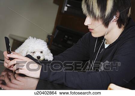 A boy listening to music on his mobile phone View Large Photo Image Picture - A boy listening to music on his mobile phone. Fotosearch