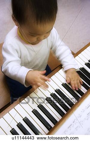 Stock Image - A child playing the piano. Fotosearch