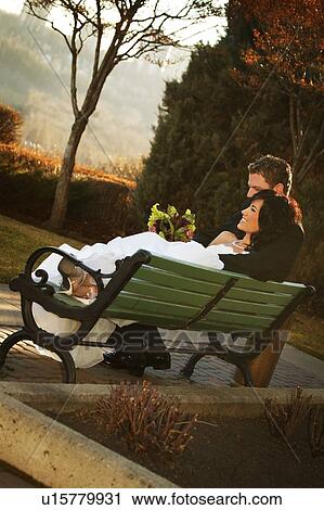 Stock Image - A couple on a bench in autumn. Fotosearch