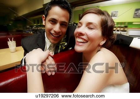Stock Photograph - A couple sitting and laughing. Fotosearch