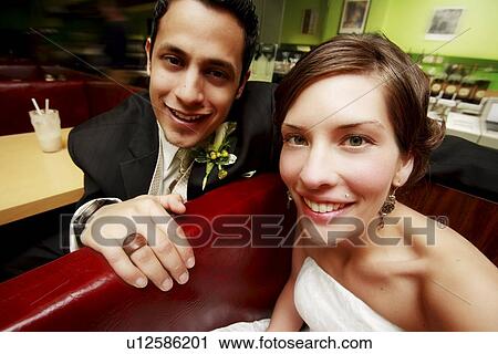 Stock Image - A couple smiling and sitting. Fotosearch