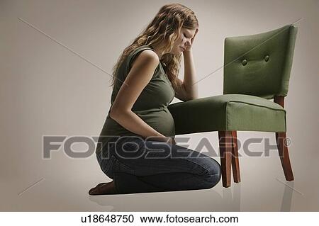 A sad pregnant woman sitting by chair View Large Photo Image Stock Image - A sad pregnant woman sitting by chair. Fotosearch