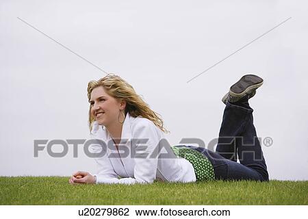 A woman smiling and laying on lawn View Large Photo Image Stock Image - A woman smiling and laying on lawn. Fotosearch