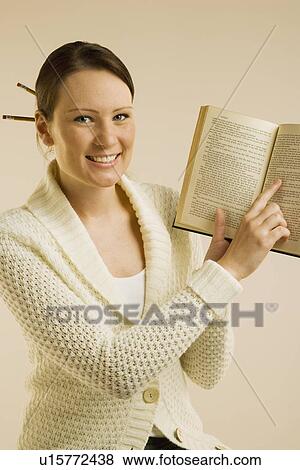 A woman smiling and showing Bible View Large Photo Image Stock Photo - A woman smiling and showing Bible. Fotosearch