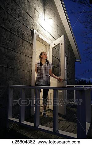 Stock Image - A woman standing at door. Fotosearch