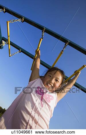 A young girl hanging from bar View Large Photo Image Stock Image - A young girl hanging from bar. Fotosearch