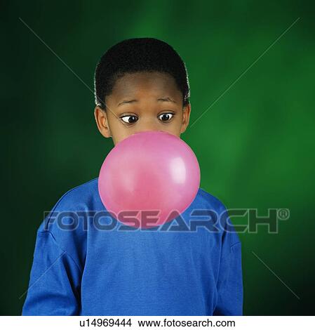 Picture - Boy blowing huge bubble with bubble gum. Fotosearch