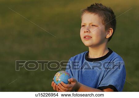 Picture - Boy holding a globe in his hands. Fotosearch