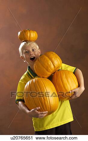 Stock Image - Boy playing with pumpkins . Fotosearch