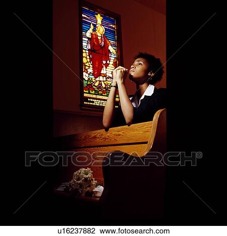 Stock Image - Boy praying in church. Fotosearch