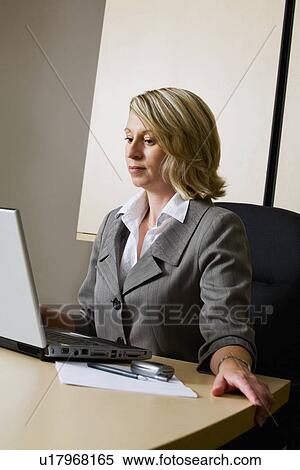 Stock Photography - Businesswoman working on laptop. Fotosearch