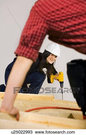 Stock Image - Carpenters working with power tools. Fotosearch