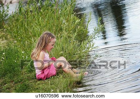 Stock Photograph - Child playing by the water. Fotosearch
