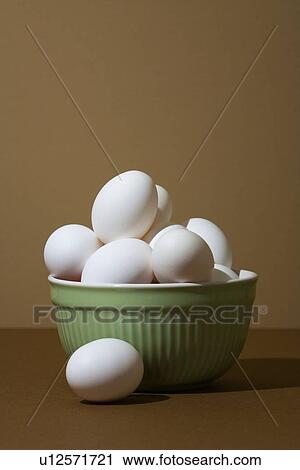 Stock Image - Closeup of white eggs in green bowl . Fotosearch
