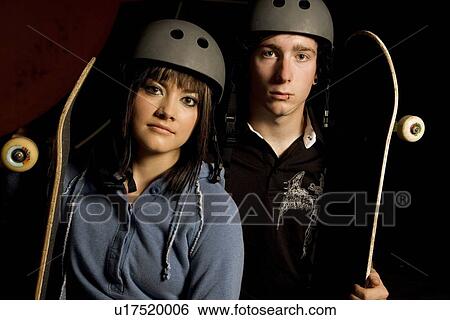 Stock Photograph - Couple holding skateboards. Fotosearch