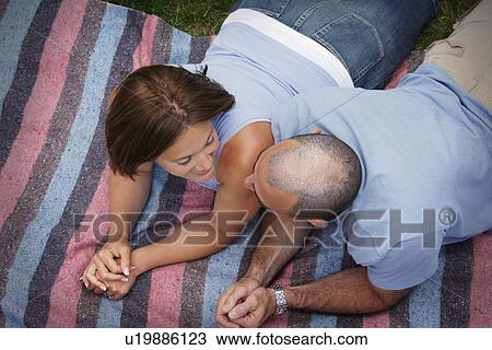 Couple laying on a blanket View Large Photo Image Stock Image - Couple laying on a blanket. Fotosearch
