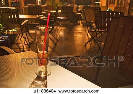 Picture - Drink in a glass with straw in an empty restaurant. Fotosearch