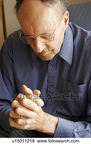 Stock Photo - Elderly man praying. Fotosearch