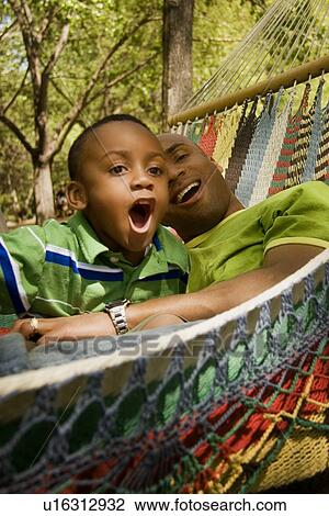 Father and son relaxing and laughing View Large Photo Image Stock Image - Father and son relaxing and laughing. Fotosearch
