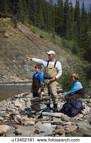 Father and sons on river shoreline View Large Photo Image Stock Image - Father and sons on river shoreline . Fotosearch