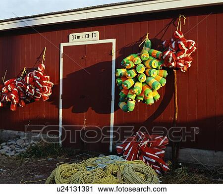 Stock Image - Fishing buoys hanging on an outside wall. Fotosearch