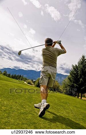 Stock Photograph - Follow through on a golfer's shot. Fotosearch