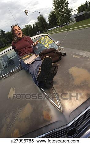 Front view of a girl sitting on car bonnet View Large Photo Image Stock Photography - Front view of a girl sitting on car bonnet. Fotosearch