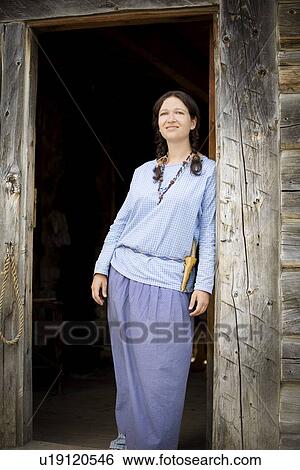 Stock Photograph - Front view of a woman standing at the door. Fotosearch