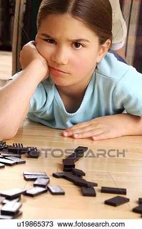 Stock Image - Girl playing dominoes. Fotosearch