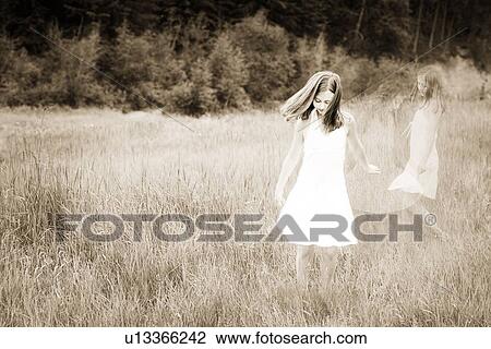 Girl playing in a field of grass View Large Photo Image Stock Image - Girl playing in a field of grass. Fotosearch