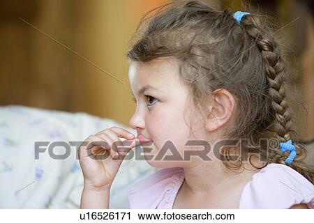 Stock Image - Girl playing with her lip. Fotosearch