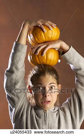Stock Image - Girl playing with pumpkins . Fotosearch